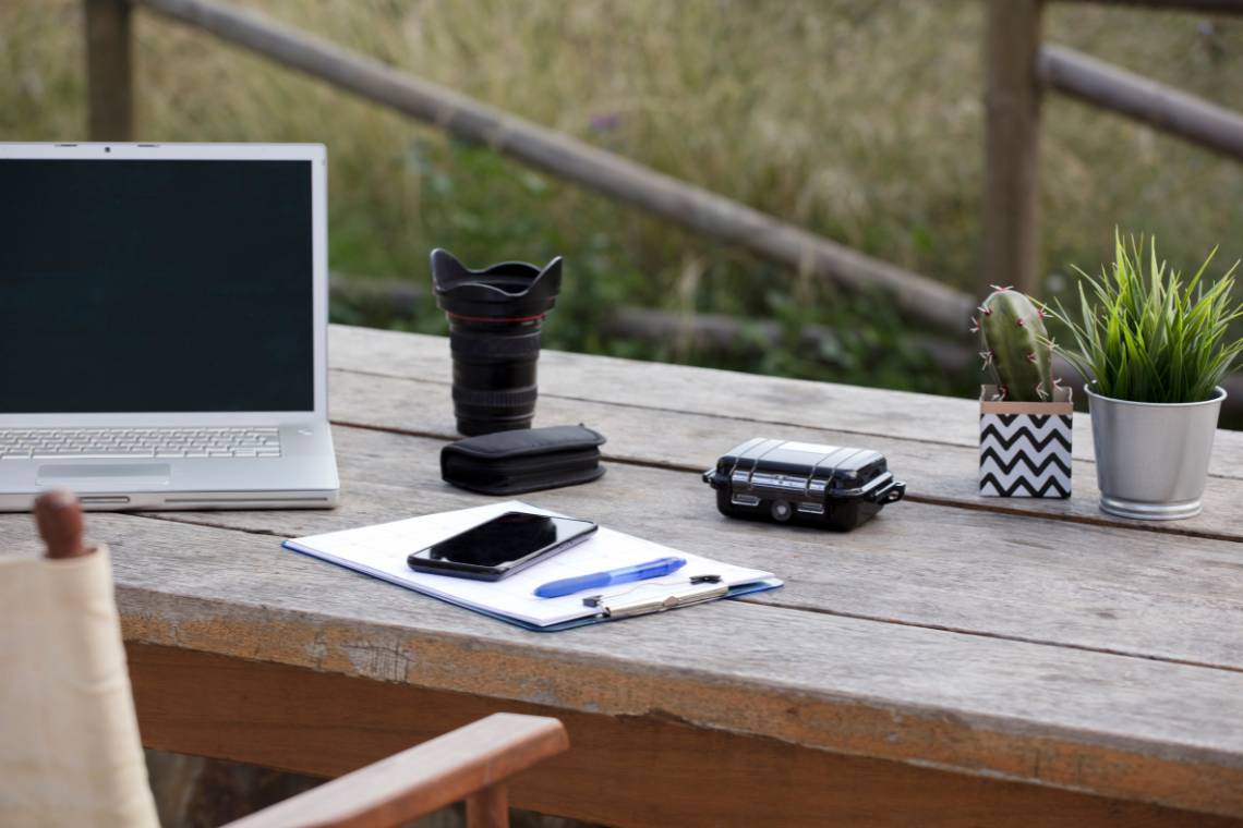 Digital nomad workspace with different working elements, natural things like leaves, and traditional radio.